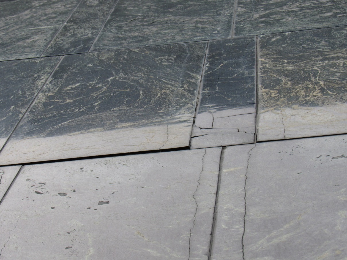 A close-up of a crack in a stone floor Description automatically generated