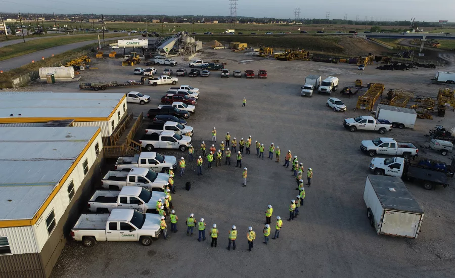 construction workers stand outside of the building
