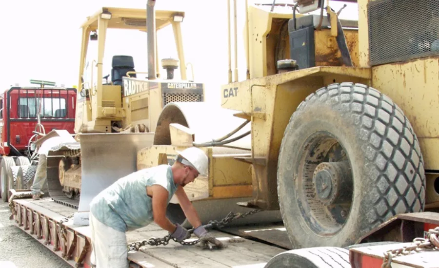 Construction worker chains a tractor