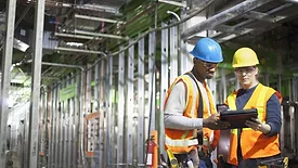 construction workers look at a tablet