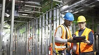 construction workers look at a tablet