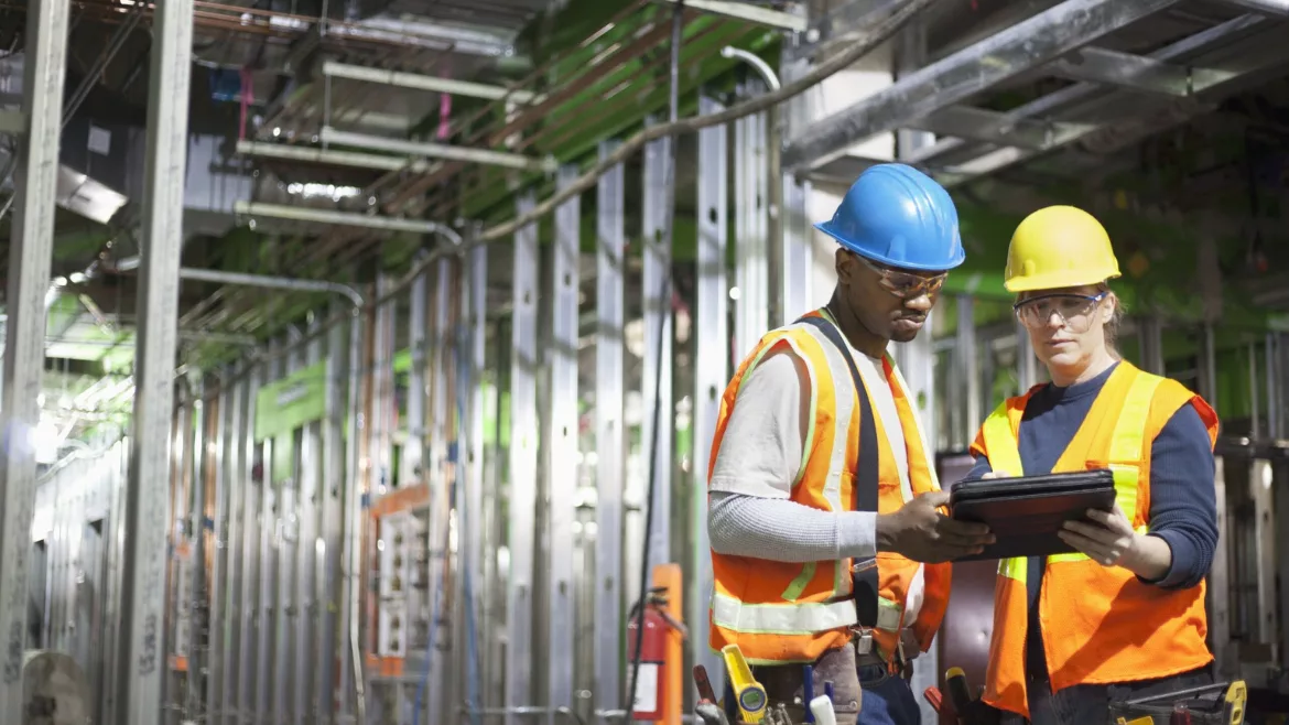 construction workers look at a tablet