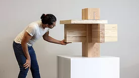 Man inspects wood blocks on top of one another