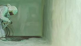 closed cell spray foam being applied in a basement