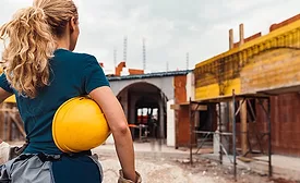 woman stands in front of construction site