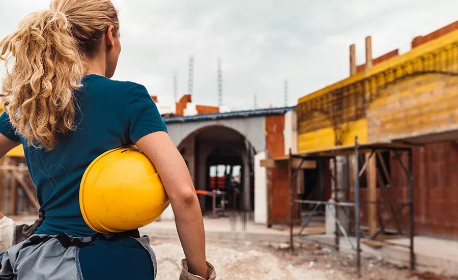woman stands in front of construction site