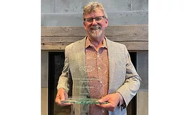 Steve Gusterson holds his award