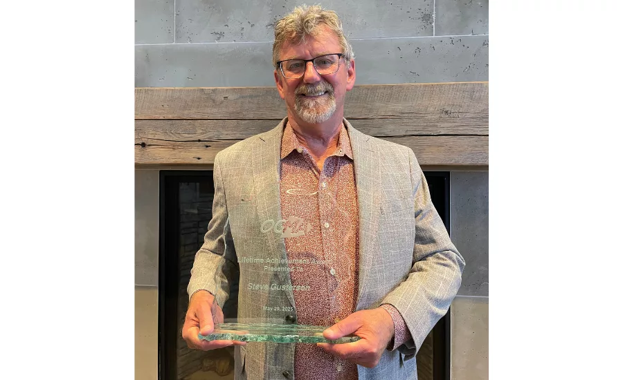 Steve Gusterson holds his award