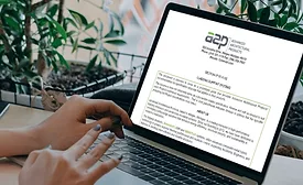 someone types at a computer with an image of a blog template