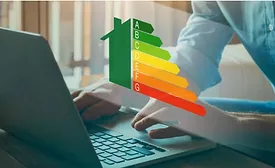 man types at computer with home energy levels