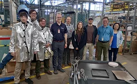 Workers stand in a manufacturing facility