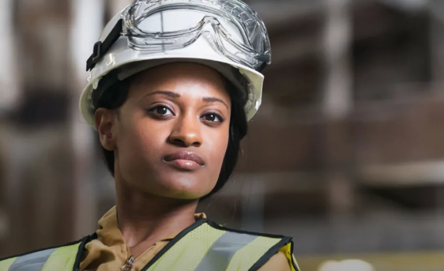 woman wears hardhat and construction safety vest