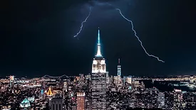 NYC skyline at night with lightning in the background