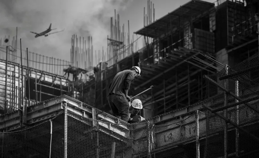 construction workers on a roof, plane flies in background