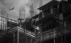 construction workers on a roof, plane flies in background