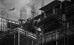 construction workers on a roof, plane flies in background