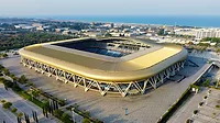 Aerial view of a modern stadium in an urban area, showcasing its unique architecture and surroundings.