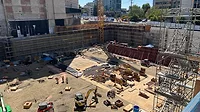 photo shows a wide shot of a construction site. The site is working on below-grade construction 