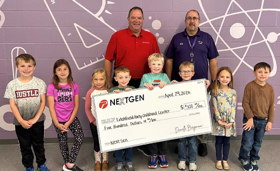 Two men stand behind eight children holding an oversized check
