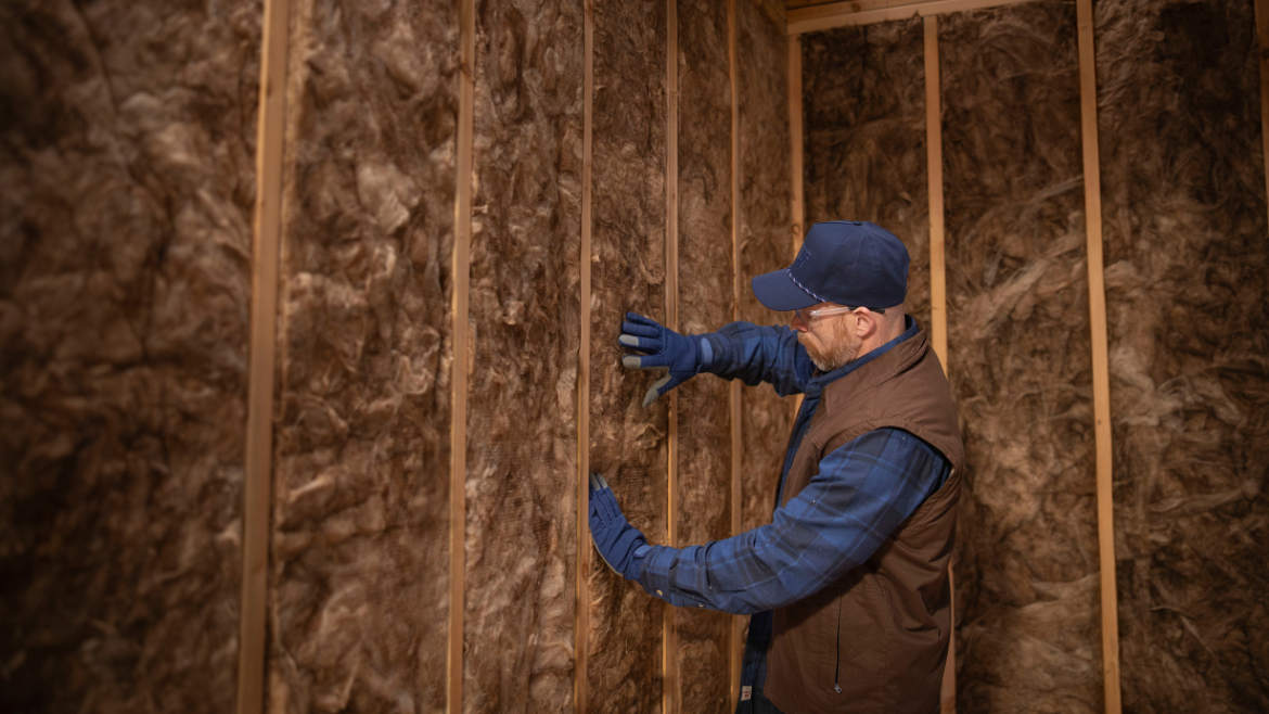 installer presses insulation between studs