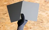 RHEINZINK-GRANUM EXTRA samples held up by a gloved hand