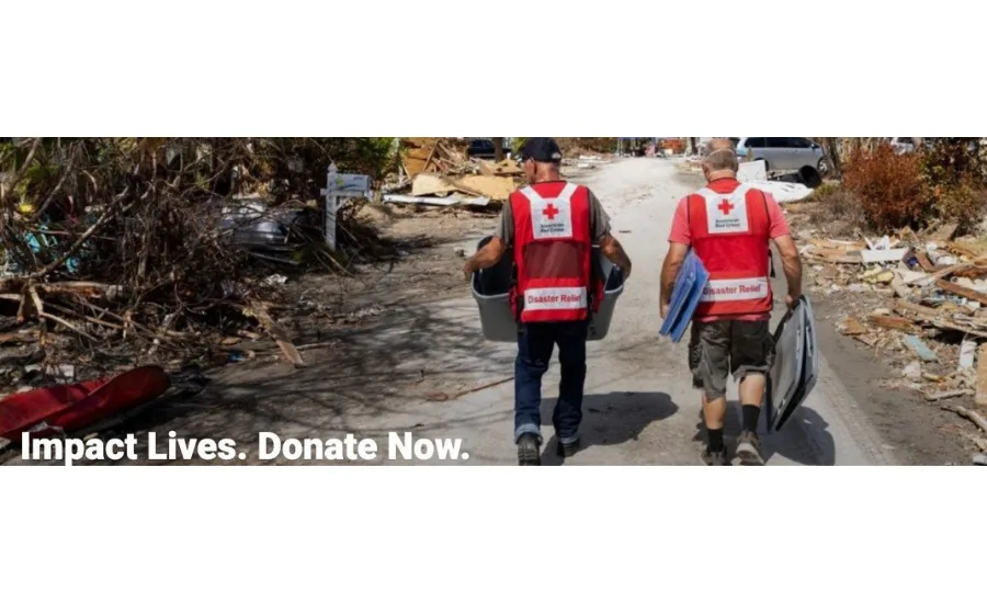 Two Red Cross workers walk in a disaster zone